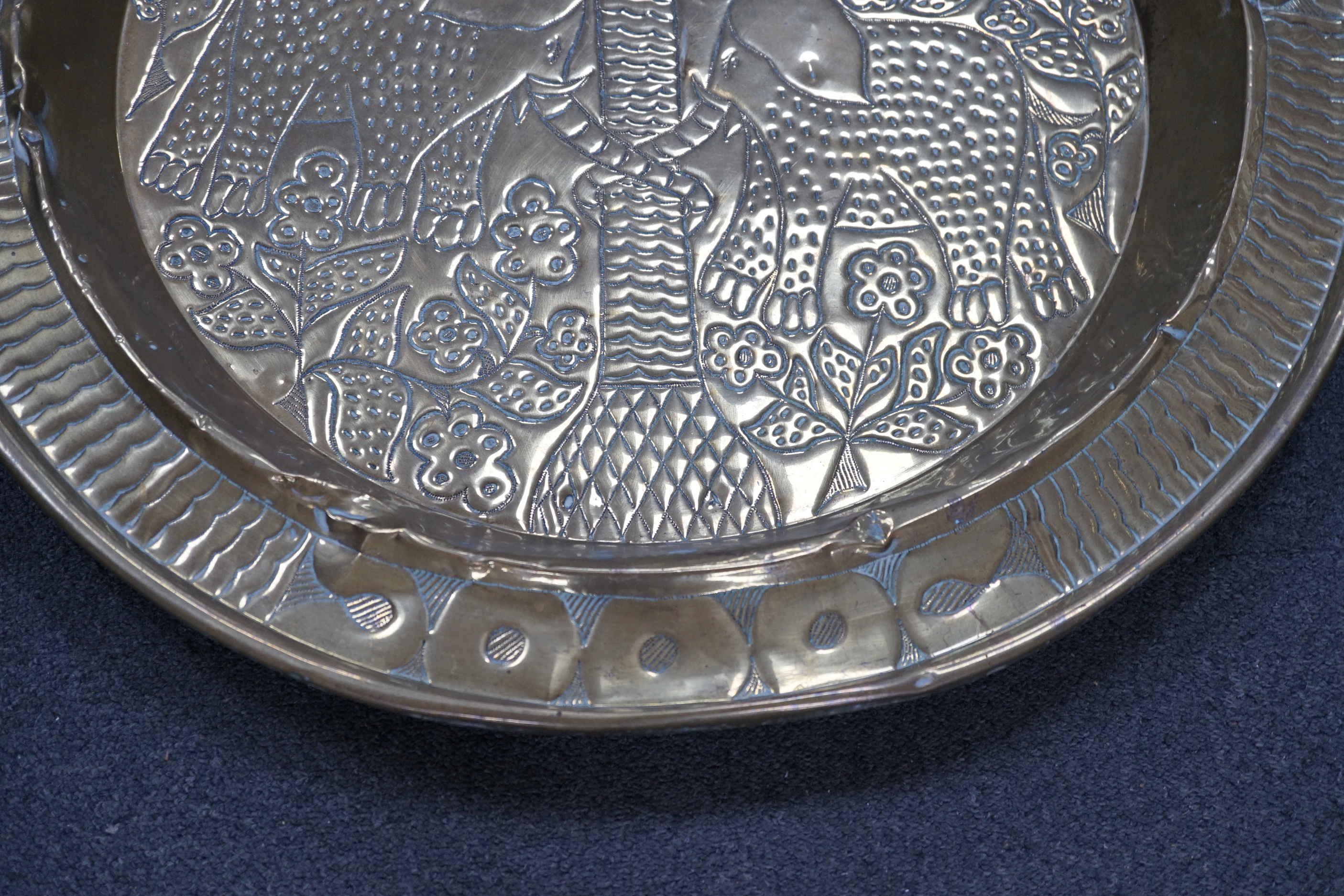 An embossed brass table top/ tray, 74cm diameter